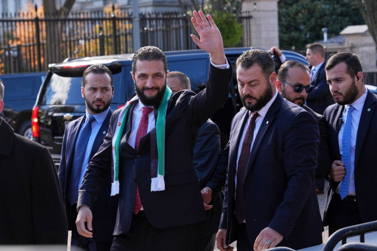 Syrian President Ahmed al Sharaa waves as he greets supporters outside the White House.