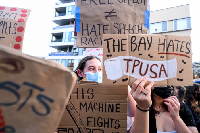 Protesters hold up anti-TPUSA signs at UC Berkeley.