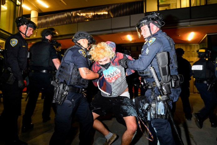 Protester detained outside oft TPUSA event.