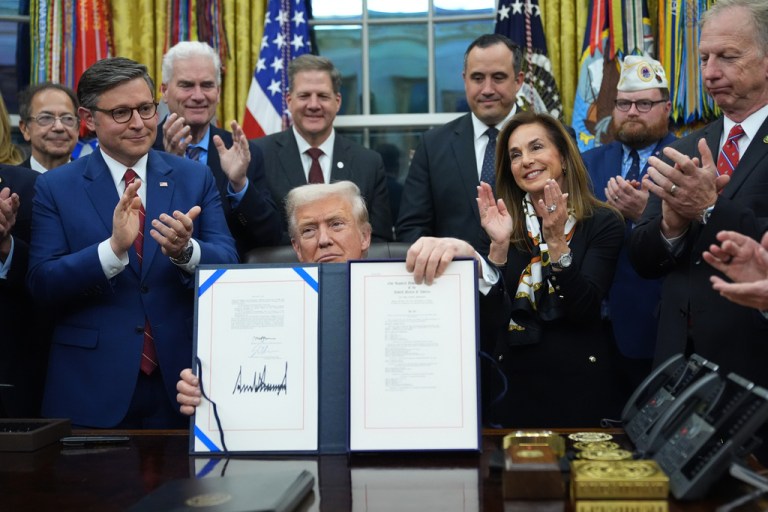 President Donald Trump displays the signed funding bill to reopen the government,