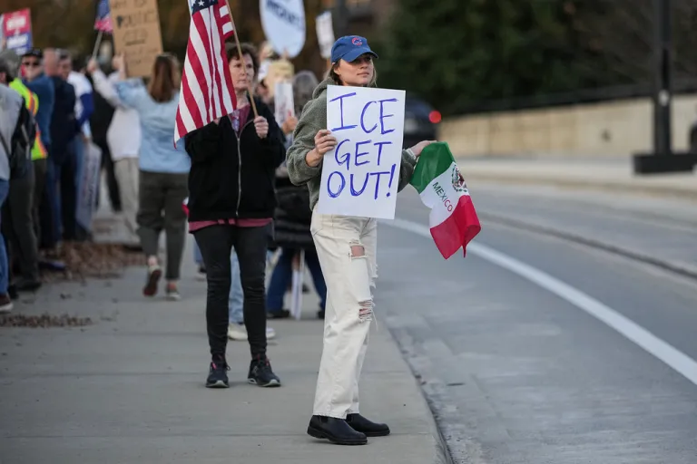 Protesters hold signs amid the arrival of federal law enforcement, Tuesday, Nov. 18, 2025, in Charlotte, N.C.