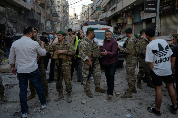Army soldiers banned people to enter the site where an Israeli strike hit at an apartment on Dahiyeh in the southern suburb of Beirut, Sunday, Nov. 23, 2025.