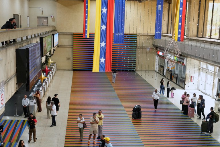 Travelers wait in the main hall of the Simon Bolivar Maiquetia International Airport in Maiquetia, Venezuela, Sunday, Nov. 23, 2025, after several international airlines canceled flights following a warning from the U.S. Federal Aviation Administration about a hazardous situation in Venezuelan airspace. (AP Photo/Ariana Cubillos)