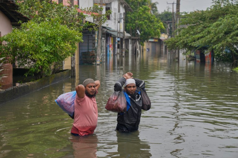 Flood victims wade through water in Colombo, Sri Lanka, Saturday, Nov, 29, 2025.