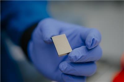 A gloved hand holds a rare earth magnet.