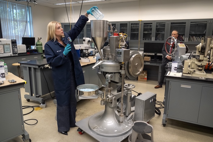 Attorney General Pam Bondi adds a mixture simulating the ingredients of fentanyl pills into a tablet press machine at a Drug Enforcement Administration (DEA) research laboratory on Tuesday, April 29, 2025, in Northern Virginia. (AP Photo/Mark Schiefelbein)