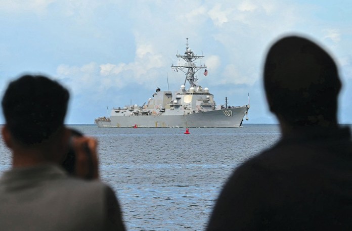 Spectators watch as the USS Gravely enters Trinidad and Tobago’s Port of Spain on Oct. 26. The U.S. warship is in the region for joint exercises near the coast of Venezuela amid Washington’s campaign against alleged drug traffickers. (MARTIN BERNETTI/AFP via Getty Images)
