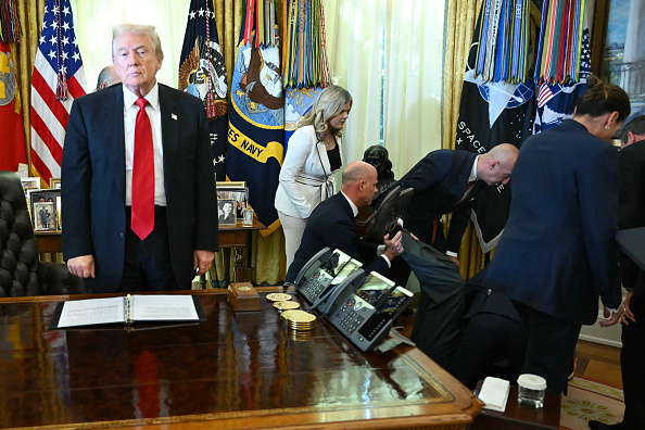 US President Donald Trump looks on after a man fainted during an announcement about weight-loss drugs in the Oval Office of the White House in Washington, DC on November 6, 2025. Trump announced deals Thursday with pharmaceutical giants Eli Lilly and Novo Nordisk to lower the prices of some popular weight-loss drugs. Both companies 