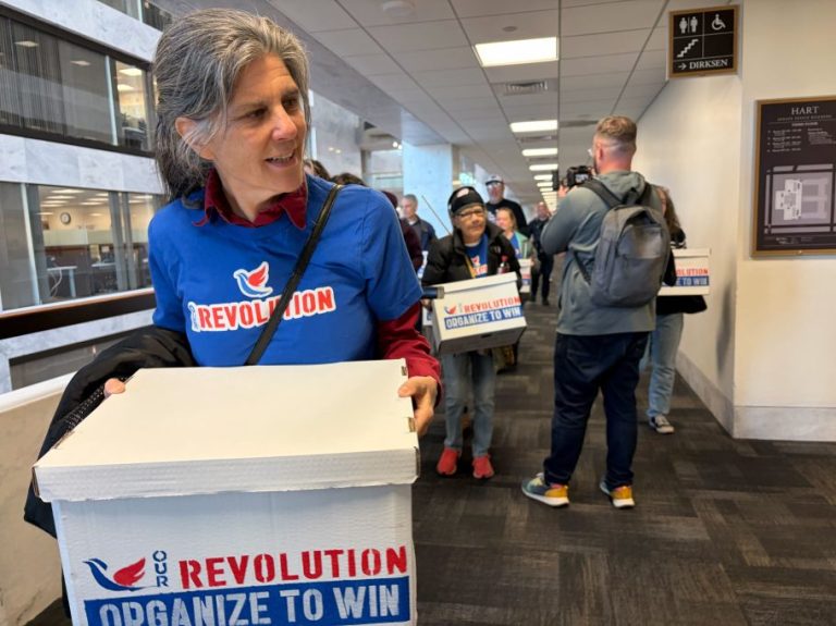 Activists with the progressive organization Our Revolution deliver digital petition signatures to Sen. Chuck Schumer (D-NY) calling on him to resign as leader of Senate Democrats