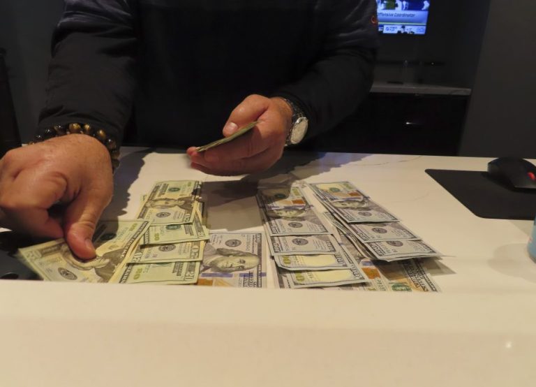 A worker at the sports book in the Ocean Casino Resort counts money on a counter.