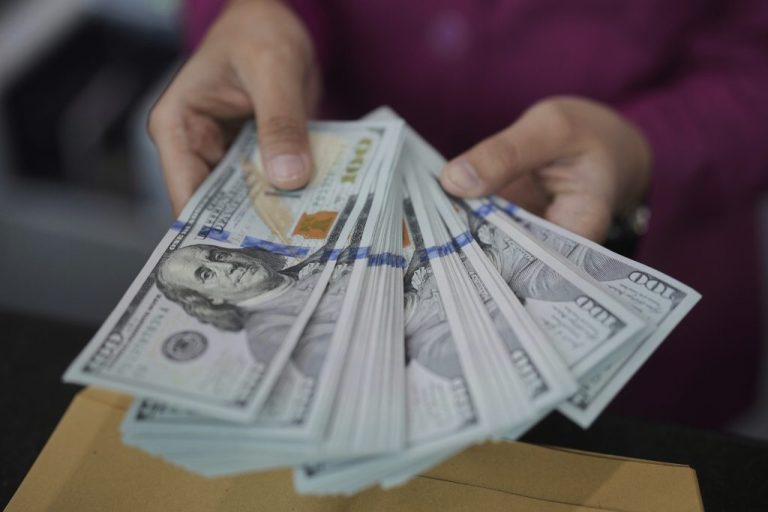 An employee shows U.S. dollars banknotes at a money changer.