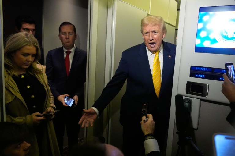President Donald Trump speaks to reporters on Air Force One.