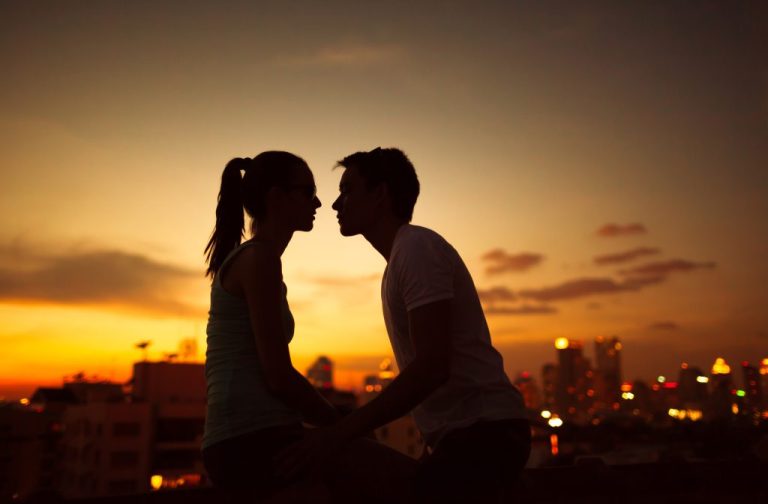 Couple kissing at night in the city.