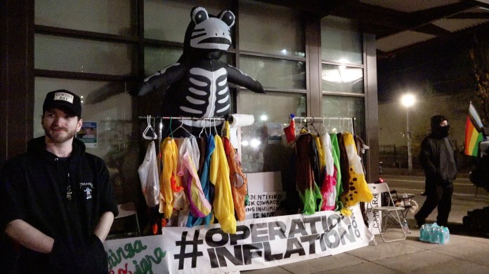 man standing next to rack of clothes