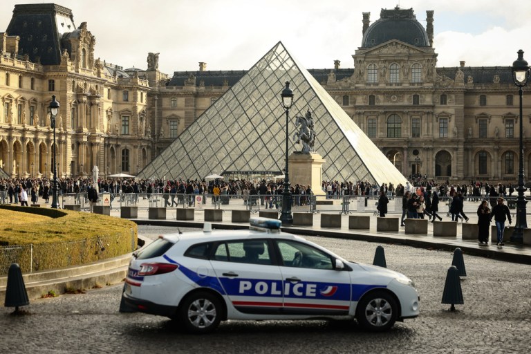 A police car parks in the courtyard of the Louvre museum.