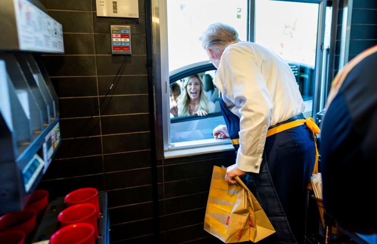 Donald Trump hands a customer an order at a drive-thru.