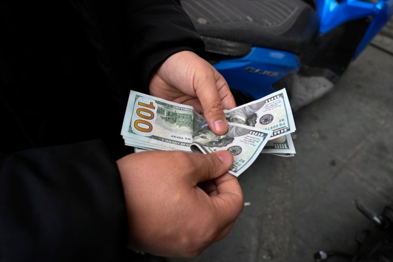 A street money exchanger counts U.S. dollars.