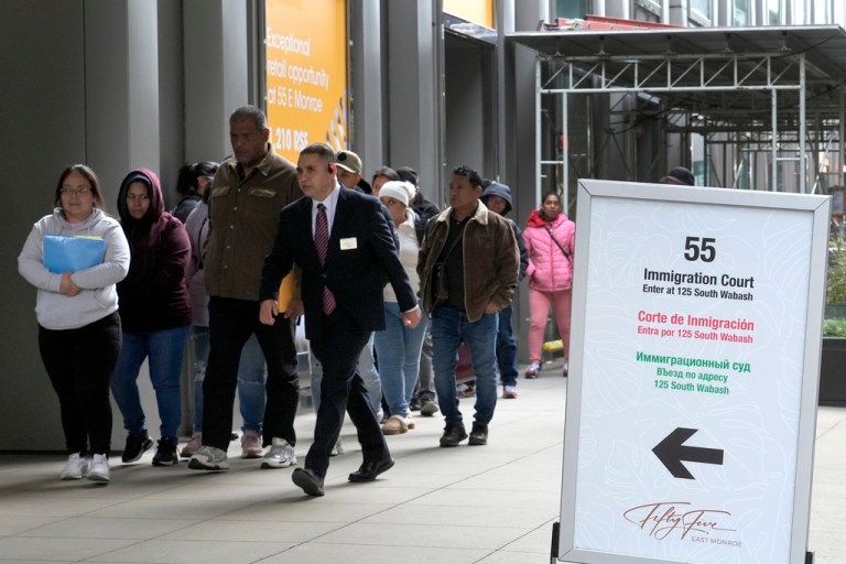 FILE - After waiting in a cue, people are led into a downtown Chicago building where an immigration court presides, Nov. 12, 2024, in Chicago. (AP Photo/Charles Rex Arbogast, File)