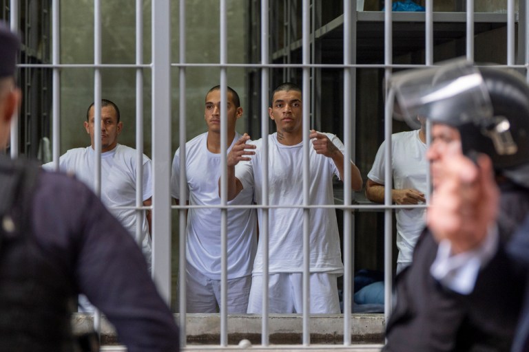 Prisoners look out their cell as Homeland Security Secretary Kristi Noem tours the Terrorism Confinement Center in Tecoluca, El Salvador