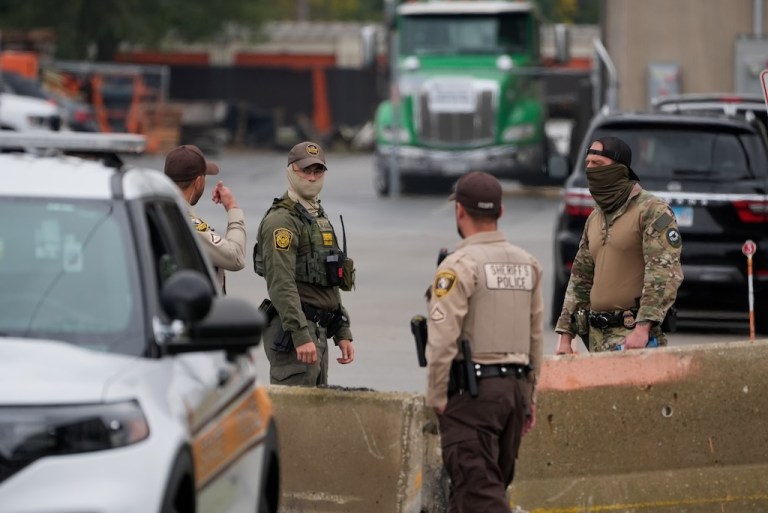 Cook County deputies and federal agents talk outside the Immigration and Customs Enforcement building.