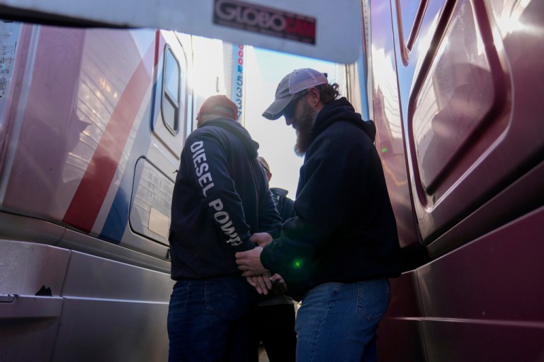 U.S. Border Patrol agents detain a truck driver during an immigration enforcement operation at a truck stop Monday, Nov. 3, 2025, in Hampshire, Ill.)