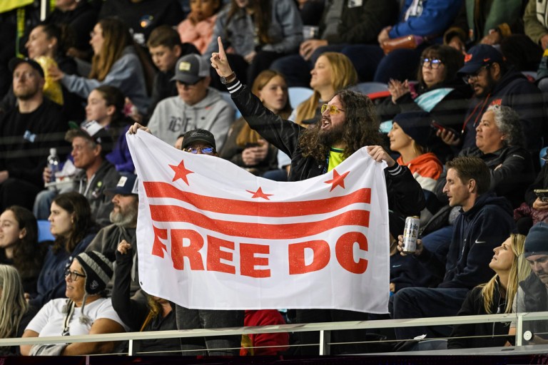 Protestors hold up a sign displaying 