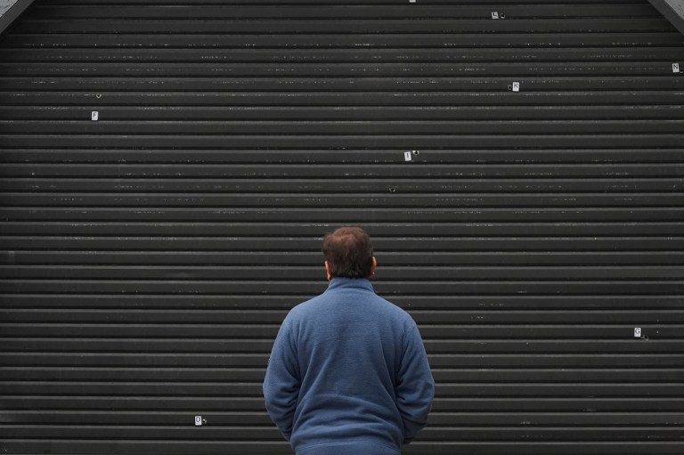 A man looks toward bullet holes where a mass shooting took place Saturday at a banquet hall in Stockton, California.