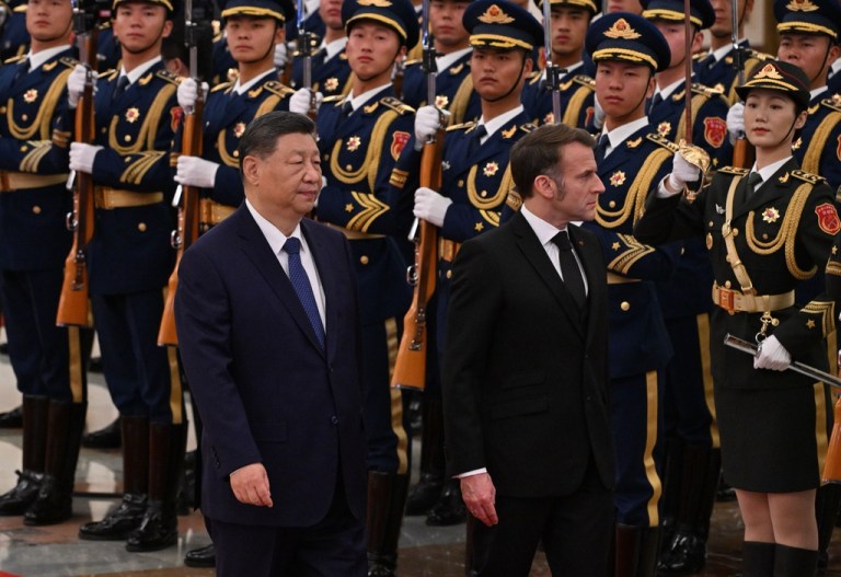 Macron and Xi walk past a Chinese military honor guard in Beijing