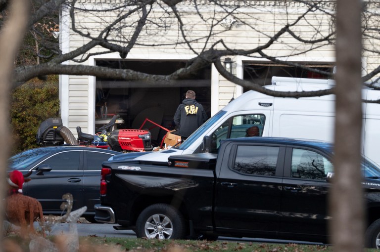 A FBI agent enters the garage of Brian Cole Jr.'s house where they made his arrest