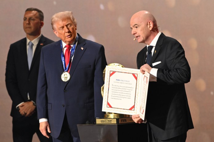 President Donald Trump looks on as FIFA President Gianni Infantino presents him with the FIFA Peace Prize.