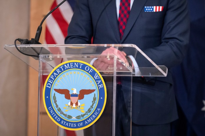 Secretary of Defense Pete Hegseth stands at a podium with a logo at the Pentagon, Wednesday, Dec. 10, 2025, in Washington