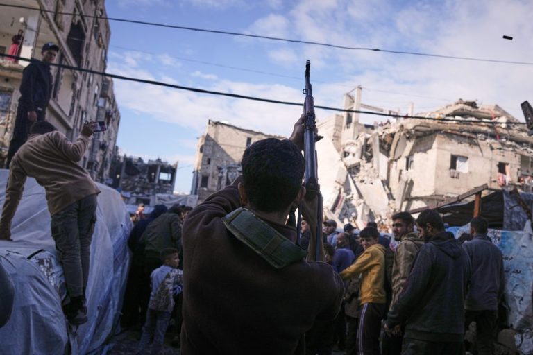 A Palestinian man fires in the air during the funeral of Hamas's Al Qassam Brigades operatives.