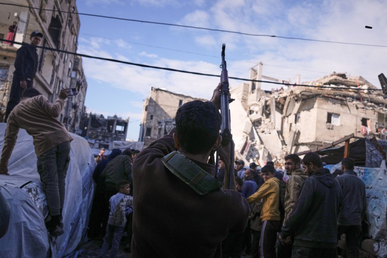 A Palestinian man fires in the air during a funeral.