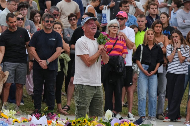 A man gestures as he lays flowers at a tribute for shooting victims outside the Bondi Pavilion at Sydney's Bondi Beach, Monday, Dec. 15, 2025, a day after a shooting.