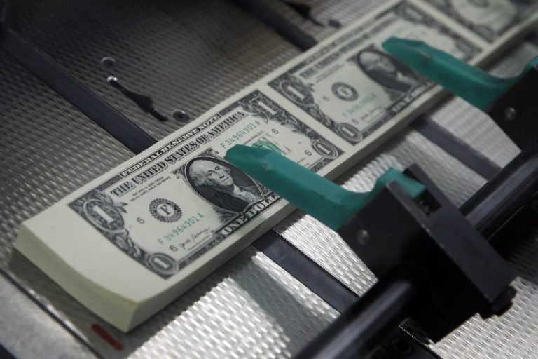 New $1 bills are cut and stacked at the Bureau of Engraving and Printing in Washington.