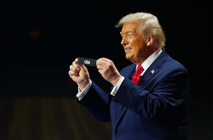 President Donald Trump holds up the name of the USA during the draw for the 2026 soccer World Cup at the Kennedy Center on Dec. 5. (Jia Haocheng/Pool Photo via AP)