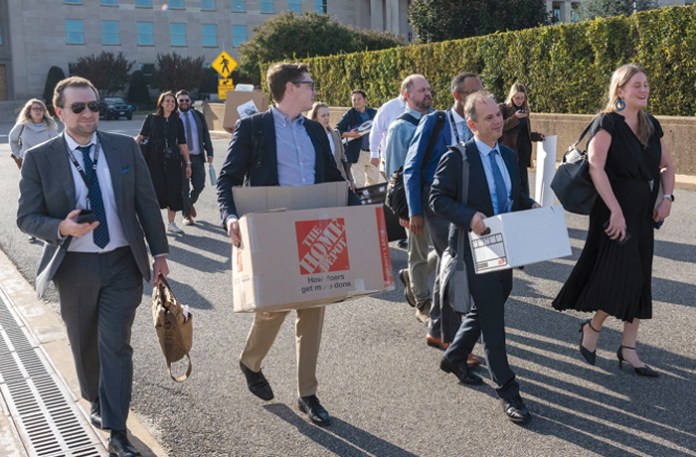 Journalists covering the military carry their belongings out of the Pentagon after turning in their press credentials. Some of the reporters who gave up their building access cards had worked at the Pentagon daily. (Kevin Wolf/AP)