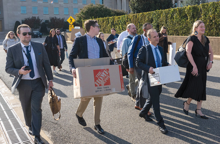 Journalists covering the military carry their belongings out of the Pentagon after turning in their press credentials. Some of the reporters who gave up their building access cards had worked at the Pentagon daily. (Kevin Wolf/AP)