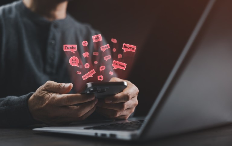 A man holding a smartphone with toxic online messages representing cyberbullying, digital harassment, and social media abuse in modern internet culture.