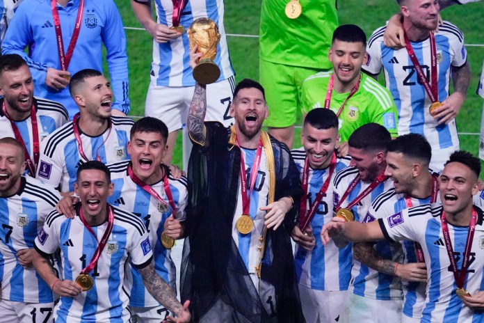 Argentina's Lionel Messi holds the trophy aloft as he celebrates with his team at the end of the World Cup final soccer match between Argentina and France at the Lusail Stadium in Lusail, Qatar, Sunday, Dec. 18, 2022. (AP Photo/Hassan Ammar, File)