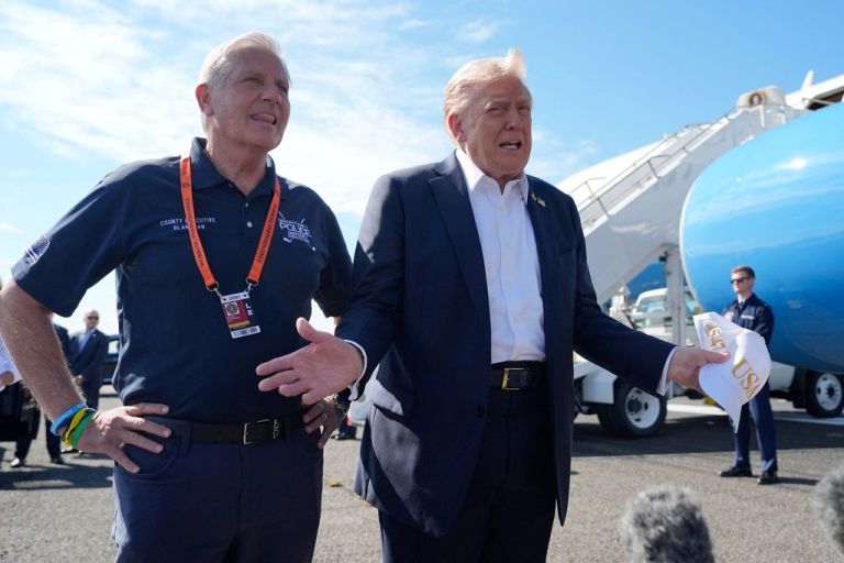 President Donald Trump speaks with reporters alongside Nassau County Executive Bruce Blakeman as Trump arrives on Air Force One at Republic Airport.