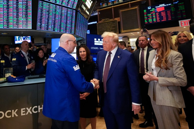 President Donald Trump, with Lynn Martin, President NYSE, center, and Melania Trump, right, is greeted by trader Peter Giacchi, as he walks the floor of the New York Stock Exchange, Thursday, Dec. 12, 2024, in New York. (AP Photo/Alex Brandon)