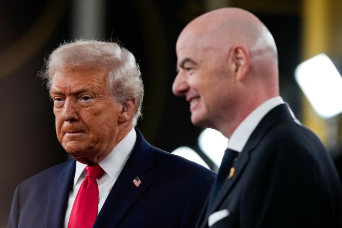 President Donald Trump, left, speaks to reporters on the red carpet as FIFA President Gianni Infantino, right, watches, while arriving to attend the draw for the 2026 soccer World Cup at the Kennedy Center, Friday, Dec. 5, 2025, in Washington. (AP Photo/Julia Demaree Nikhinson)