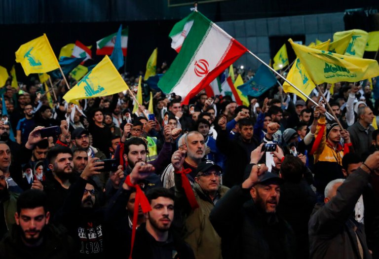 Hezbollah supporters shout slogans and wave Lebanese, Hezbollah, and Iranian flags during a rally to commemorate the 40th anniversary of Iran's Islamic Revolution.