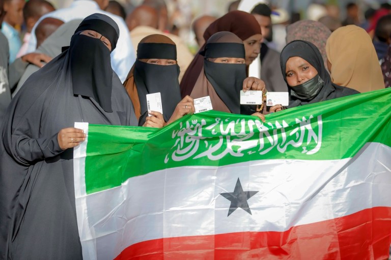 People display the Somaliland flag as they wait to cast their vote during the 2024 Somaliland presidential election at a polling station in Hargeisa, Somaliland, Wednesday, Nov. 13,2024.