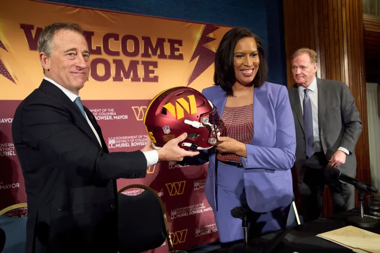 Washington Commanders controlling owner Josh Harris, from left, holds up a signed helmet along with District of Columbia Mayor Muriel Bowser and NFL Commissioner Roger Goodell after an announcement about a new home for the NFL football team on the site of the old RFK Stadium, Monday, April 28, 2025, at the National Press Club in Washington. (AP Photo/Jacquelyn Martin)
