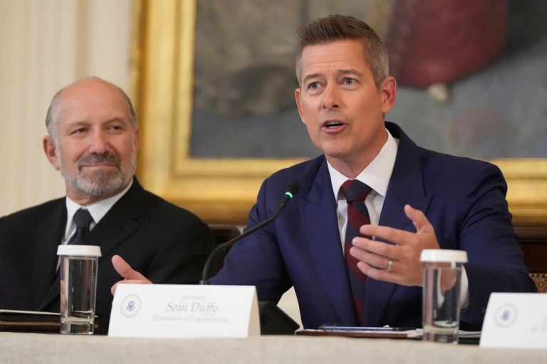 Commerce Secretary Howard Lutnick listens as Transportation Secretary Sean Duffy speaks during a FIFA task force meeting on the 2026 FIFA World Cup with President Donald Trump in the East Room of the White House.