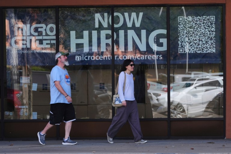 Pedestrians walk by a 