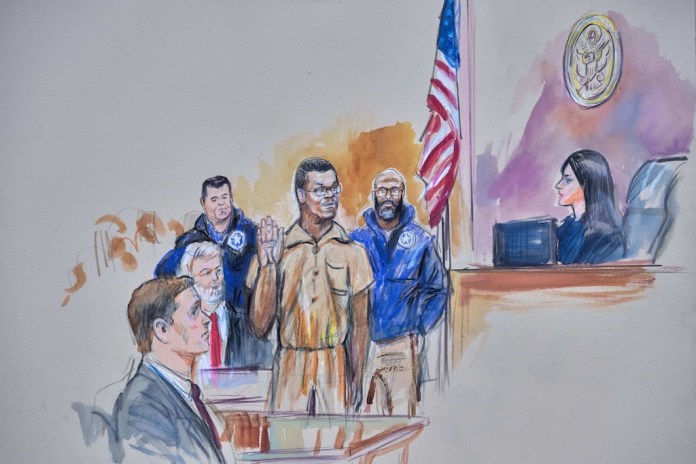 A courtroom sketch depicting Brian Cole Jr., 30, of Woodbridge, Virginia, the man accused of planting a pair of pipe bombs outside the headquarters of the Republican and Democratic national parties on Jan. 5, 2021, in Washington, being sworn in, Friday, Dec. 5, 2025, before U.S. Magistrate Moxila Upadhyaya, at Federal Court in Washington, as U.S. Attorney Charles Jones, seated left, and Defense Attorney John Shoreman, seated center, look on.