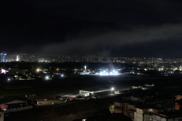 Smoke raises at La Carlota airport after explosions and low-flying aircraft were heard in Caracas, Venezuela, Saturday, Jan. 3, 2026. (AP Photo/Matias Delacroix)